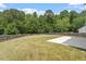 Large, grassy backyard with a wooded area and fence at 15 Epping Ct, Durham, NC 27703