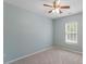 Light-filled bedroom with carpeted floors, ceiling fan, and large window at 15 Epping Ct, Durham, NC 27703