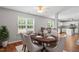 Inviting dining area with a large window and an elegant table, adjacent to an open kitchen with bar seating at 15 Epping Ct, Durham, NC 27703
