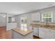 Kitchen with white cabinets, an island with granite countertops, and stainless steel appliances at 15 Epping Ct, Durham, NC 27703