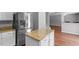 Bright kitchen featuring stainless steel refrigerator, granite countertops, and white cabinetry at 15 Epping Ct, Durham, NC 27703