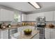 Bright and airy kitchen with white cabinetry, granite countertops, and stainless steel appliances offers a clean, modern space at 15 Epping Ct, Durham, NC 27703