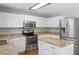Modern kitchen with stainless steel appliances, granite countertops, and white cabinets at 15 Epping Ct, Durham, NC 27703