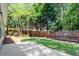 Spacious backyard featuring a lush lawn, wooden fence, mature trees, and a concrete patio at 1608 Hayesville Dr, Fuquay Varina, NC 27526
