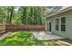 Backyard view with lush lawn, wooden fence, patio, and mature trees surrounding the property at 1608 Hayesville Dr, Fuquay Varina, NC 27526