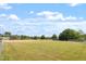 Open grass baseball field with blue sky and white clouds in the background at 1608 Hayesville Dr, Fuquay Varina, NC 27526