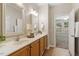Well-lit bathroom with double sinks, wooden cabinets, and tile flooring at 1608 Hayesville Dr, Fuquay Varina, NC 27526
