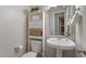Cozy half-bathroom featuring a pedestal sink, decorative shelving, and updated fixtures at 1608 Hayesville Dr, Fuquay Varina, NC 27526