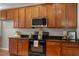 Well-lit kitchen featuring wood cabinets, granite countertops, and stainless steel microwave at 1608 Hayesville Dr, Fuquay Varina, NC 27526