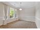 Bright living room with neutral walls and carpet, large windows, and elegant crown molding at 1608 Hayesville Dr, Fuquay Varina, NC 27526
