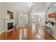 Sunlit open-concept living room with hardwood floors, fireplace, and backyard access at 1608 Hayesville Dr, Fuquay Varina, NC 27526