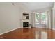 Living room featuring hardwood floors, a fireplace and backyard access at 1608 Hayesville Dr, Fuquay Varina, NC 27526
