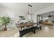 Bright dining room with a long wooden table, bench seating, modern chandelier, and an open floor plan at 1616 Silo Ridge Dr, Wake Forest, NC 27587