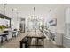 Modern dining area with a long table, stylish light fixture, and ample natural light at 1616 Silo Ridge Dr, Wake Forest, NC 27587