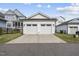 Two-car garage with white doors and a spacious driveway, complemented by well-maintained landscaping at 1616 Silo Ridge Dr, Wake Forest, NC 27587