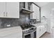 Close up of kitchen featuring stainless steel range and hood, marble countertops, and white cabinets at 1616 Silo Ridge Dr, Wake Forest, NC 27587