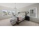 Bright main bedroom features a large bed, a chandelier, and lots of natural light from several windows at 1616 Silo Ridge Dr, Wake Forest, NC 27587