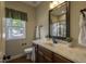 Well-lit bathroom with a marble countertop, wood cabinets, and a window at 199 Courtney Ln, Dunn, NC 28334