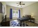 Cozy bedroom featuring a ceiling fan, patterned rug, and a window with blue curtains at 199 Courtney Ln, Dunn, NC 28334