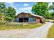 Rustic barn featuring wood construction, metal siding, and ample open space with a gravel driveway at 206 Kittys Ln, Erwin, NC 28339