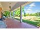 Inviting covered porch with tiled flooring, porch swing, and views of the expansive lawn at 206 Kittys Ln, Erwin, NC 28339