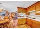 Open-concept kitchen with wood cabinetry, tile countertops, and hardwood floors adjoins dining and living spaces at 206 Kittys Ln, Erwin, NC 28339