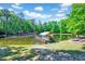 Picturesque pond featuring a charming dock with a covered seating area and lush surrounding trees at 206 Kittys Ln, Erwin, NC 28339