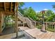 Multi-level wooden back deck, accessible by stairs, under the shade of mature trees at 209 E Winston St, Youngsville, NC 27596