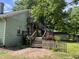 Exterior view featuring a wooden deck and stairs, accented by a quaint white picket fence at 209 E Winston St, Youngsville, NC 27596