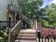 Outdoor deck featuring multi-level stairs, wooden railings, and a charming backyard view, perfect for entertaining at 209 E Winston St, Youngsville, NC 27596