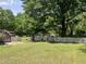 Lush backyard featuring mature trees and a charming white picket fence at 209 E Winston St, Youngsville, NC 27596