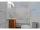 Cozy bathroom with a wooden vanity, white toilet, and shower with bathtub at 209 E Winston St, Youngsville, NC 27596