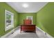 Bedroom with green walls featuring a window view and wood bed at 209 E Winston St, Youngsville, NC 27596