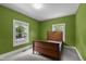 Bedroom with green walls and natural light and wood bed at 209 E Winston St, Youngsville, NC 27596