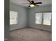 Bedroom with neutral carpet, ceiling fan and windows offering ample natural light at 209 E Winston St, Youngsville, NC 27596