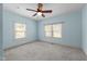 Bedroom with two windows providing natural light and blue walls and ceiling fan at 209 E Winston St, Youngsville, NC 27596
