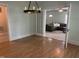 Open dining space leading to the living room, with hardwood floors and modern light fixture at 209 E Winston St, Youngsville, NC 27596