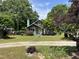 A charming single-story home with mature trees and a well-manicured lawn at 209 E Winston St, Youngsville, NC 27596