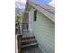 Upper level deck and entry of a home with green siding and wooden stairs at 209 E Winston St, Youngsville, NC 27596