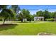 Spacious front yard with lush green grass, mature trees, and a glimpse of the house's exterior at 209 E Winston St, Youngsville, NC 27596
