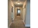 Hallway with neutral walls leading to a door with a sheer curtain at 209 E Winston St, Youngsville, NC 27596