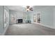 Bright living room with fireplace, ceiling fan, light blue walls, and natural light from the windows at 209 E Winston St, Youngsville, NC 27596