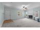 Light blue living room with a fireplace, ceiling fan, and multiple windows for natural light at 209 E Winston St, Youngsville, NC 27596