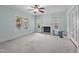 Living room featuring a fireplace, ceiling fan, light blue walls, and natural light at 209 E Winston St, Youngsville, NC 27596
