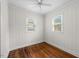 Cozy bedroom with hardwood floors, two windows bringing in light, and painted wood paneled walls at 212 Northwood Cir, Durham, NC 27701
