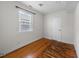 Cozy bedroom features hardwood floors, a white door, and a window with blinds for natural light at 212 Northwood Cir, Durham, NC 27701