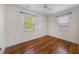 Bright bedroom with hardwood floors, neutral walls, a ceiling fan and two windows with blinds at 212 Northwood Cir, Durham, NC 27701