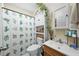 Cozy bathroom with floral curtain, decorative plants, and a wooden vanity with sink at 214 Northwood Cir, Durham, NC 27701