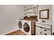 Convenient laundry room with modern washer and dryer units, complemented by stylish wooden accents at 215 Graduate Ct, Durham, NC 27713