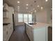 Bright kitchen boasts an island with sink, stainless appliances, and modern pendant lighting at 2323 Hunter Woods Dr # 566, Apex, NC 27502